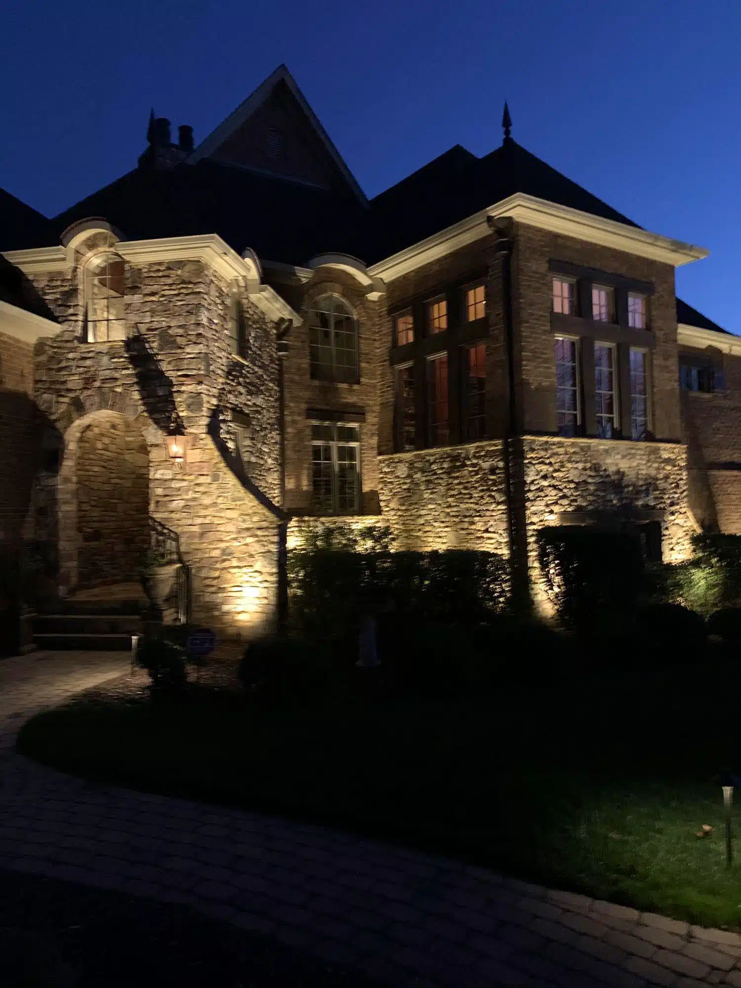 Outdoor lighting illuminating the front stone exterior of a home by Landscape Lighting Resources in Charlotte NC